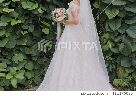 bride with a bouquet of flowers in the park 111170056