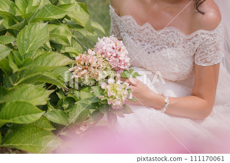 bride with a bouquet of flowers in the park 111170061