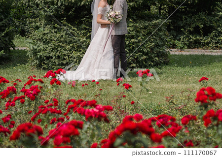 bride and groom in a park with flowers 111170067