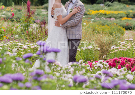 bride and groom in a park with flowers bride and groom in a park with flowers 111170070