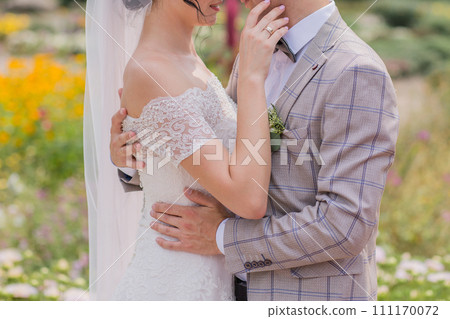bride and groom in a park with flowers bride and groom in a park with flowers 111170072