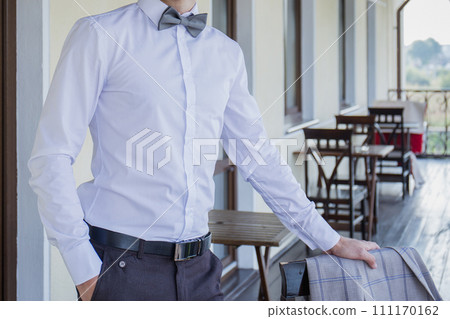 man puts on a suit on the veranda 111170162
