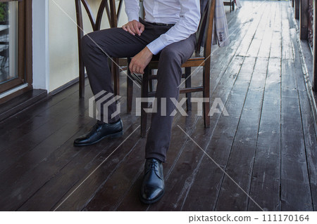 man puts on a suit on the veranda man puts on a suit on the veranda 111170164
