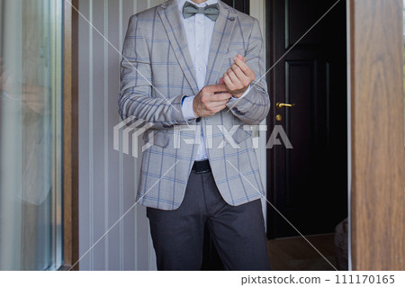 man puts on a suit on the veranda man puts on a suit on the veranda 111170165