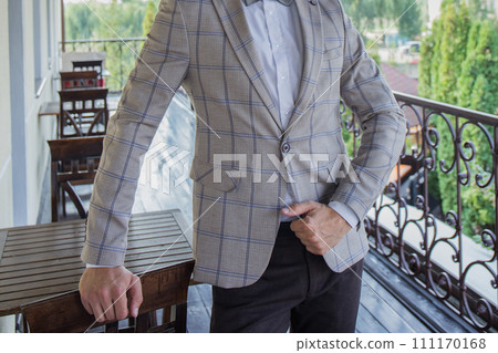 man puts on a suit on the veranda man puts on a suit on the veranda 111170168