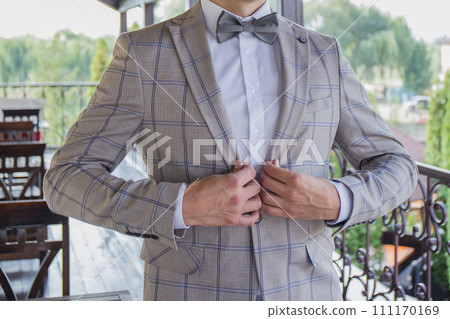 man puts on a suit on the veranda man puts on a suit on the veranda 111170169