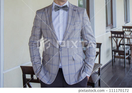 man puts on a suit on the veranda 111170172