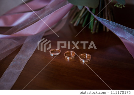 wedding gold rings with a bouquet of the bride 111170175