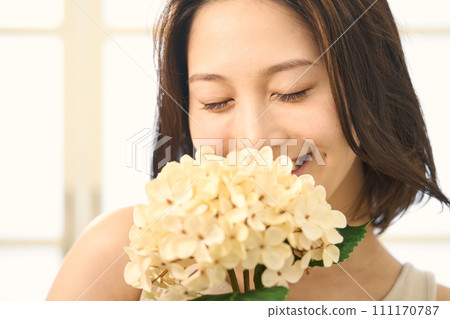 A woman holding a hydrangea in her hand 111170787