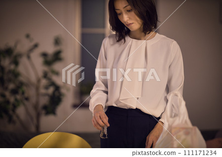 Night routine of a business woman who takes off her jacket and watch Night routine of a business woman who takes off her jacket and watch 111171234