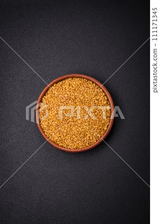 Bulgur wheat grains are yellow in color when raw Bulgur wheat grains are yellow in color when raw 111171345