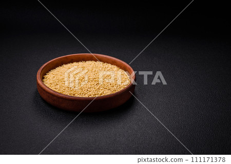 Raw risoni pasta made from durum wheat on a dark concrete background 111171378