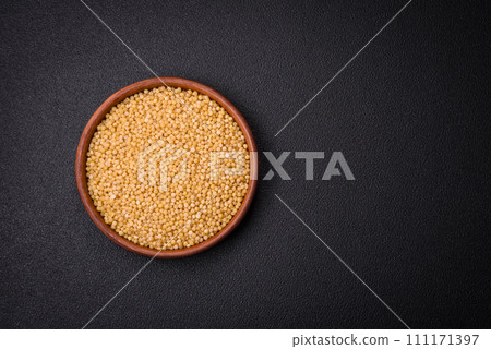 Ptitim wheat porridge grains on a dark concrete background 111171397