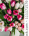 a vase filled with pink and white tulips 111171570