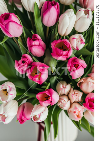 a vase filled with pink and white tulips 111171570