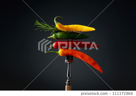 Hot chili peppers with rosemary on a fork. 111172868