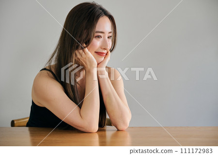 一名 30 多歲的女性，長髮，身穿黑色吊帶背心 111172983