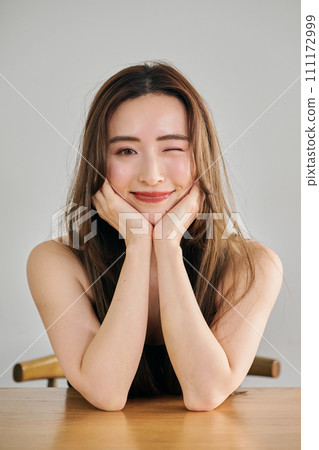 A woman in her 30s with long hair wearing a black camisole 111172999