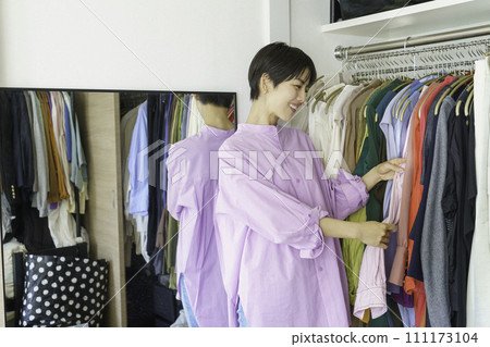 早上從衣櫃裡挑選衣服的年輕女人 早上從衣櫃裡挑選衣服的年輕女人 111173104