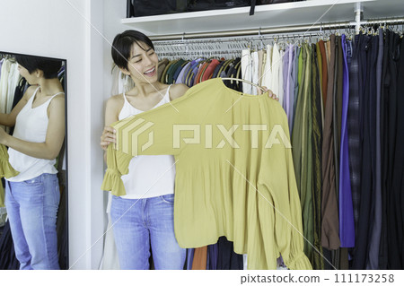 Young woman choosing clothes from closet in the morning 111173258