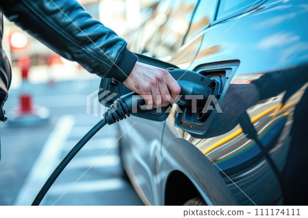 Electric car or EV is charging, Hand inserting EV charging plug to electric vehicle Electric car or EV is charging, Hand inserting EV charging plug to electric vehicle 111174111