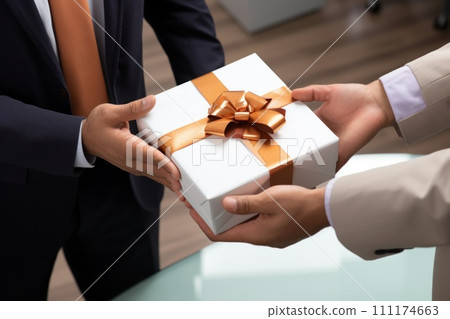 Close-up view of hands Giving a business gift in an office Close-up view of hands Giving a business gift in an office 111174663
