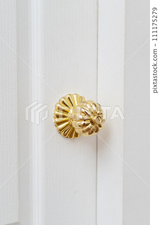gold door knob handle. reflective surface and modern design add touch of luxury to entrance door. Crafted with metal and wood, this round knob shines with style and security. 111175279