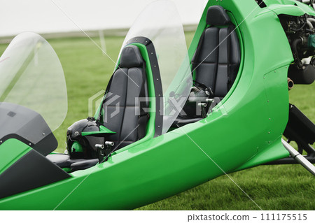 Two-seater green gyrocopter at the airfield 111175515
