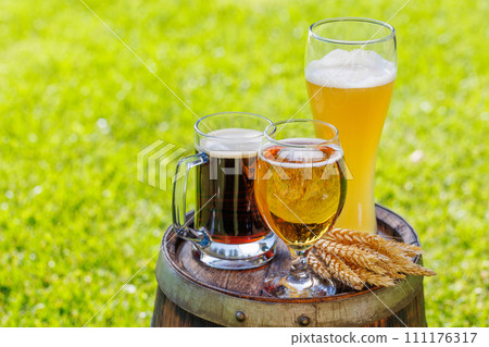 Variety of beer glasses on rustic wooden barrel 111176317
