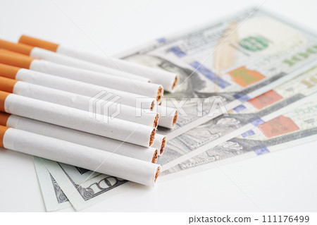 Cigarette on US dollar banknotes, cost, trading, marketing and production, No smoking concept. Cigarette on US dollar banknotes, cost, trading, marketing and production, No smoking concept. 111176499