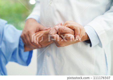 Doctor holding hands Asian elderly woman patient, help and care in hospital. 111176507