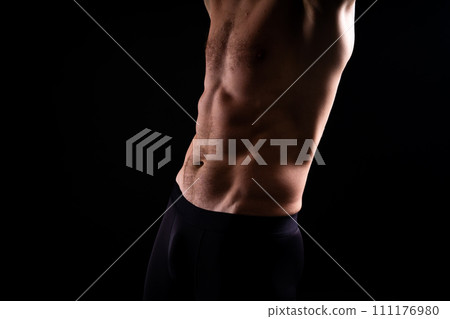Handsome bodybuldier man posing showing muscle, shirtless torso showing pectorals and sixpack Handsome bodybuldier man posing showing muscle, shirtless torso showing pectorals and sixpack 111176980