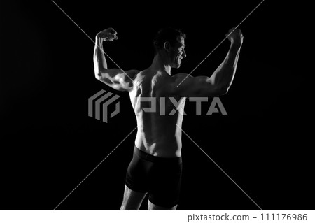 Handsome bodybuldier man posing showing muscle, shirtless torso showing pectorals and sixpack 111176986