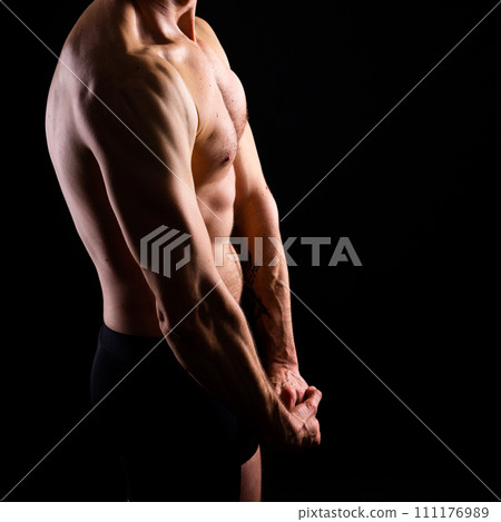 Handsome bodybuldier man posing showing muscle, shirtless torso showing pectorals and sixpack Handsome bodybuldier man posing showing muscle, shirtless torso showing pectorals and sixpack 111176989