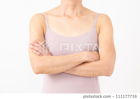 身穿吊帶背心、雙臂交叉的中年婦女 身穿吊帶背心、雙臂交叉的中年婦女 111177739