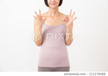 穿著吊帶背心的中年婦女用手指做圓形標誌 穿著吊帶背心的中年婦女用手指做圓形標誌 111178488