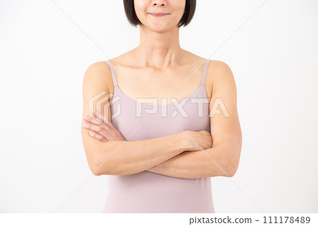 身穿吊帶背心、雙臂交叉的中年婦女 身穿吊帶背心、雙臂交叉的中年婦女 111178489