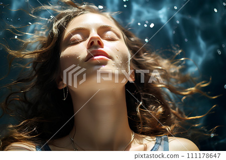 Beautiful woman is in a clear and clean blue swimming pool. She closed her eyes and relaxed. The sun shines on her She is enjoying the summer vacation. This image represents happiness and relaxation. 111178647