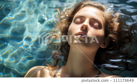 Beautiful woman is in a clear and clean blue swimming pool. She closed her eyes and relaxed. The sun shines on her She is enjoying the summer vacation. This image represents happiness and relaxation. 111178649