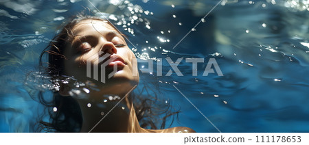 Beautiful woman is in a clear and clean blue swimming pool. She closed her eyes and relaxed. The sun shines on her She is enjoying the summer vacation. This image represents happiness and relaxation. Beautiful woman is in a clear and clean blue swimming pool. She closed her eyes and relaxed. The sun shines on her She is enjoying the summer vacation. This image represents happiness and relaxation. 111178653