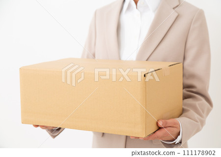 穿著西裝的中年婦女攜帶紙箱行李 111178902