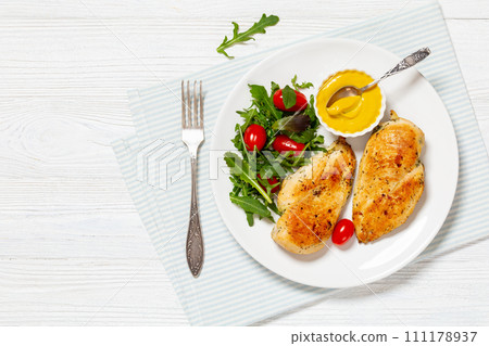 fried chicken breasts with green salad on plate 111178937