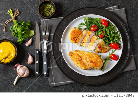 fried chicken breasts with green salad on plate 111178942