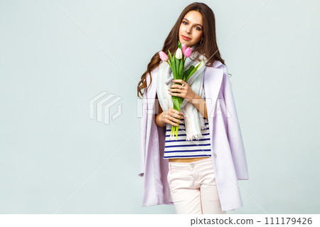 Fashion photo of beautiful woman with tulips in her hand. March 8. beautiful girl in stylish clothes Fashion photo of beautiful woman with tulips in her hand. March 8. beautiful girl in stylish clothes 111179426
