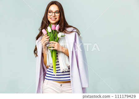 Fashion photo of beautiful woman with tulips in her hand. March 8. beautiful girl in stylish clothes Fashion photo of beautiful woman with tulips in her hand. March 8. beautiful girl in stylish clothes 111179429