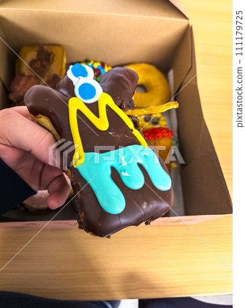 Multi-colored donuts in a box from the Voodoo Donut retail store in Portland. 111179725