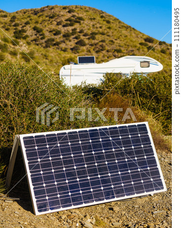 Solar photovoltaic panel and camper in the distance 111180495