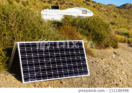 Solar photovoltaic panel and camper in the distance Solar photovoltaic panel and camper in the distance 111180496