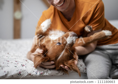 Smiling man with dog at home. 111180663