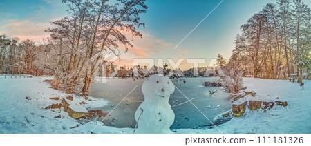 Picture over a frozen lake in the morning light with a snowman Picture over a frozen lake in the morning light with a snowman 111181326